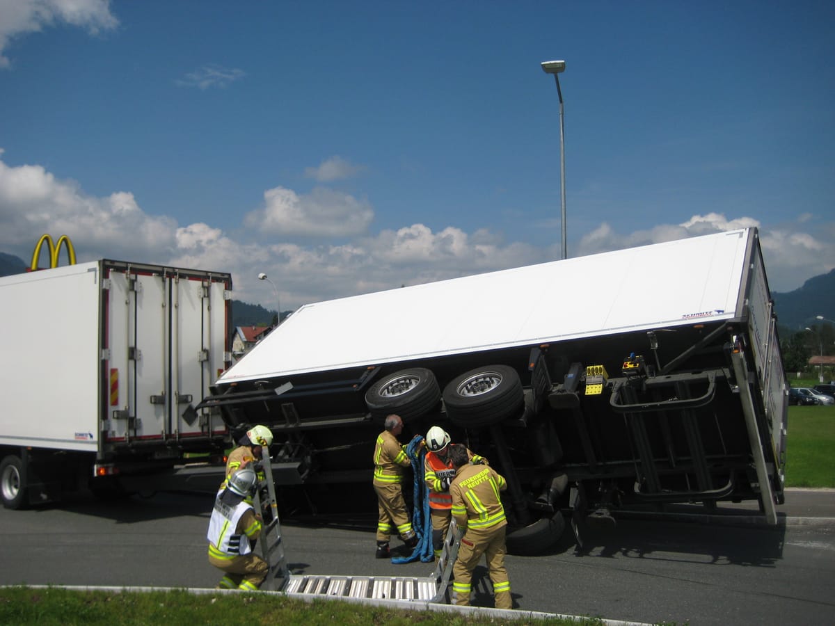 LKW Anhänger liegt im Kreisverkehr auf der Seite